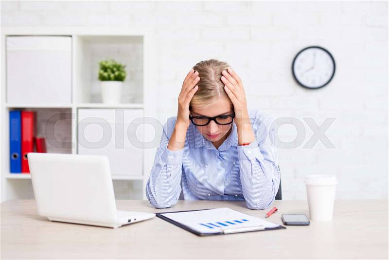 Tired business woman sitting in modern office, stock photo