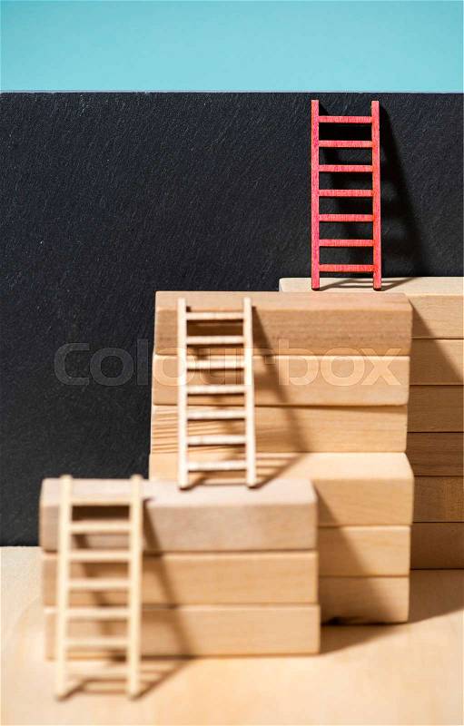 Ladders on the wall. Concept for success and growth. Stairs made of wooden blocks. Blue wall. , stock photo