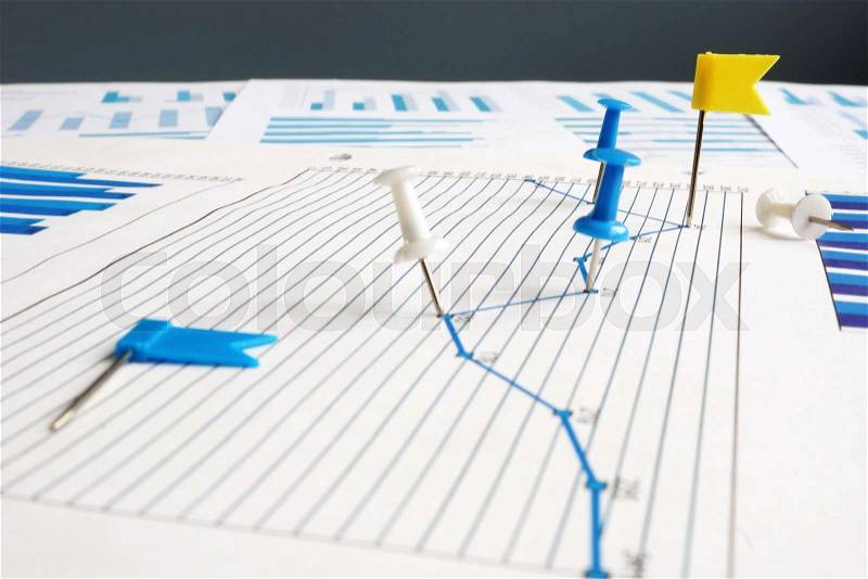 KPI key performance indicators. Thumb tacks and business papers, stock photo