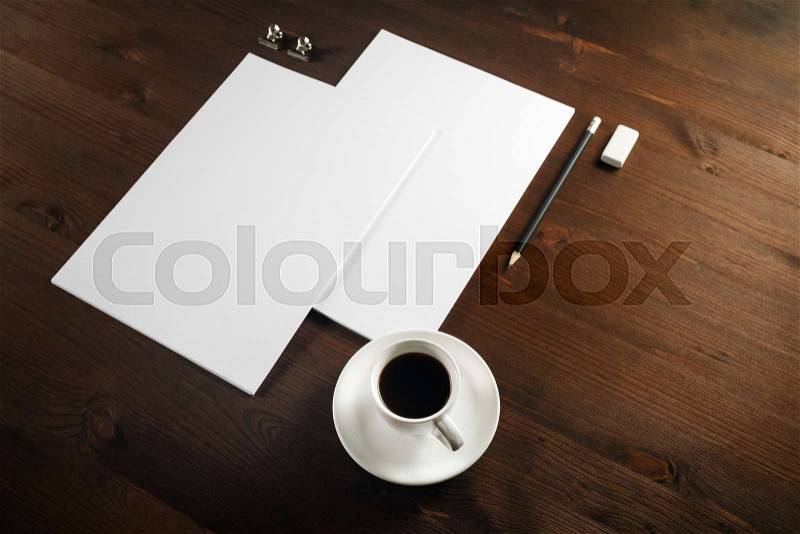 Photo of blank stationery set on wood table background. Blank letterhead, coffee cup, pencil and eraser, stock photo