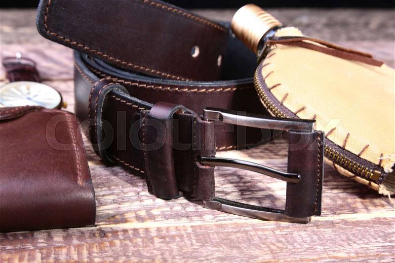 Watch, leather belt and wallet, bottle with cologne on wooden background. Stylish mens business accessories, stock photo