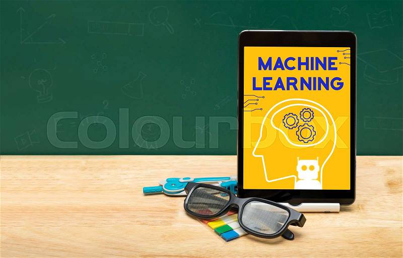 Machine learning bot on tablet with glasses on wood table and green blackboard with copy space for adding text.Artificial intelligence learning concept, stock photo