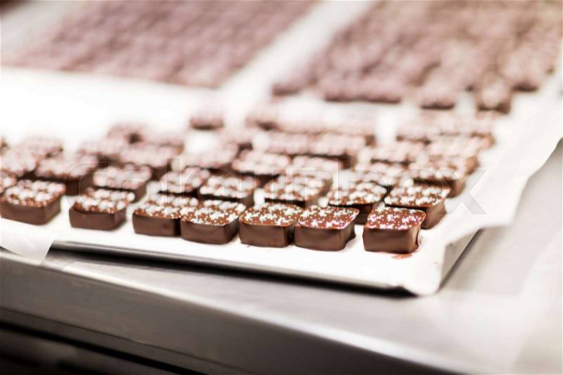 Sweets production and industry concept - chocolate candies at confectionery shop, stock photo