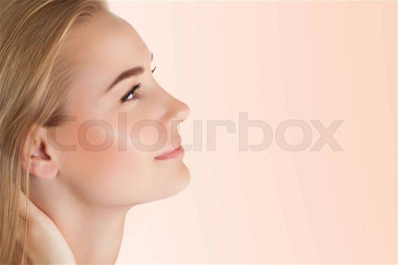 Profile portrait of a pretty woman with perfect skin isolated on clear background, using anti acne or anti aging cream, health and beauty care concept, stock photo