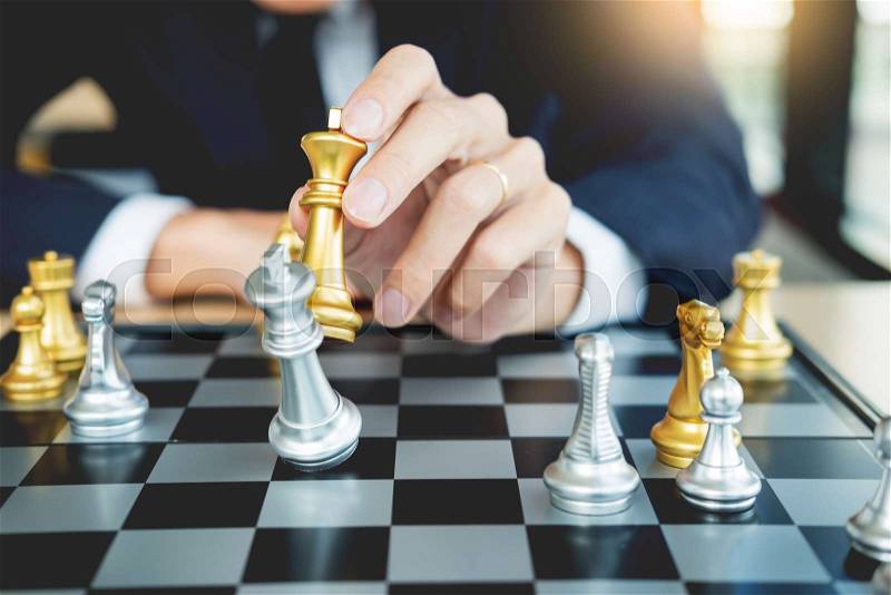 Businessman playing chess figure take a checkmate another king with team, strategy or management win or success concept, stock photo