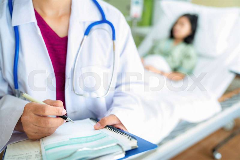 Doctor write a report after visit a patient on the bed in hospital, this photo can use for health, insurance, hospital, doctor and patient concept, stock photo