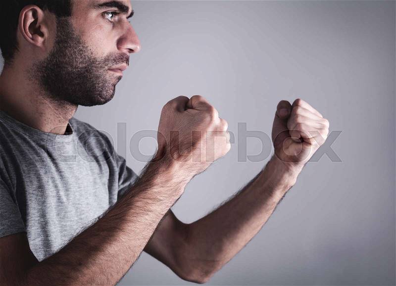 Caucasian angry and aggressive man threatening with fists, stock photo