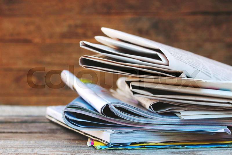 Newspapers and magazines on old wood background. Toned image. , stock photo