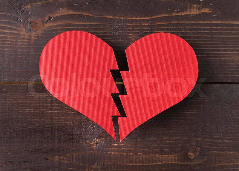 Paper broken heart on wooden background, stock photo