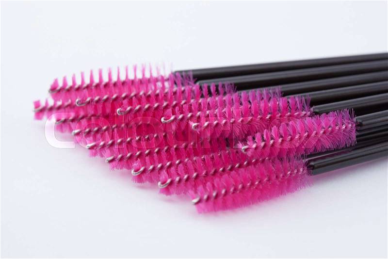 Pink brushes for eyelashes and eyebrows on a white background, stock photo