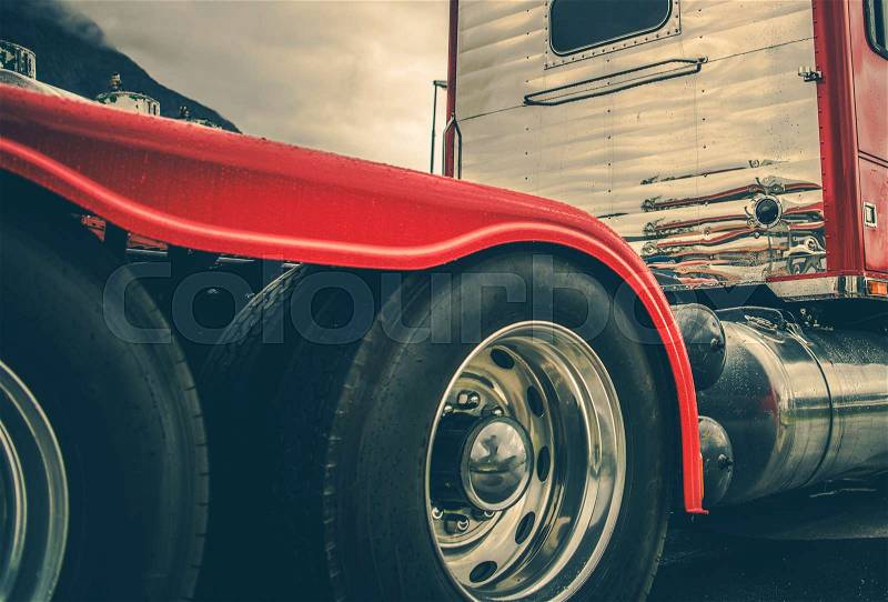 Semi Truck Heavy Duty Tires and Chromed Alloy Wheels. Driving in a Heavy Rain Conditions. Modern Truck Tractor Rear Wheels. Automotive Industry, stock photo