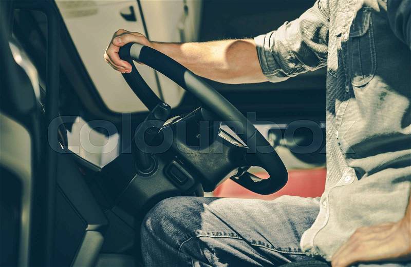 Caucasian Semi Truck Driver Behind the Wheel. Transportation Industry Concept, stock photo