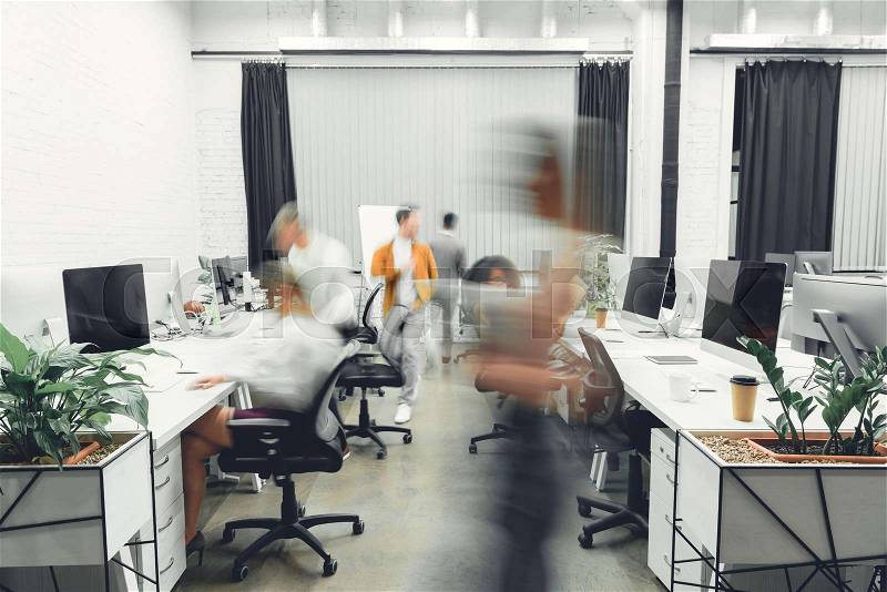 Contemporary open space office interior with blurred coworkers in motion , stock photo