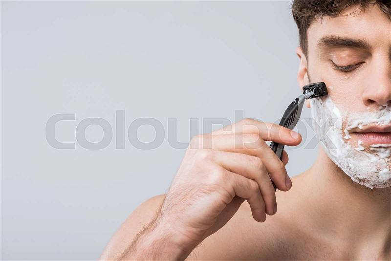 Handsome young man foam on face shaving with razor, isolated on grey, stock photo