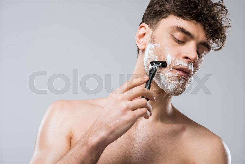 Handsome caucasian man foam on face shaving with razor, isolated on grey, stock photo