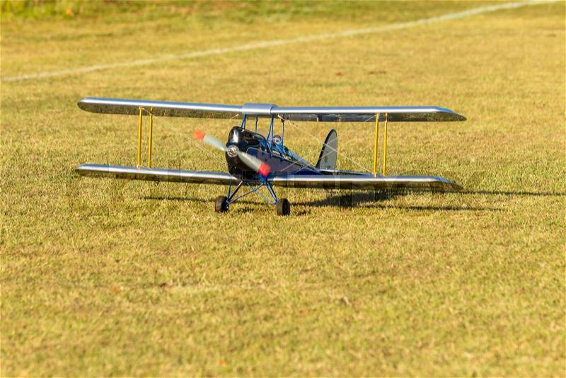 Flying model aircraft rmc unidentified male controller on open field, stock photo