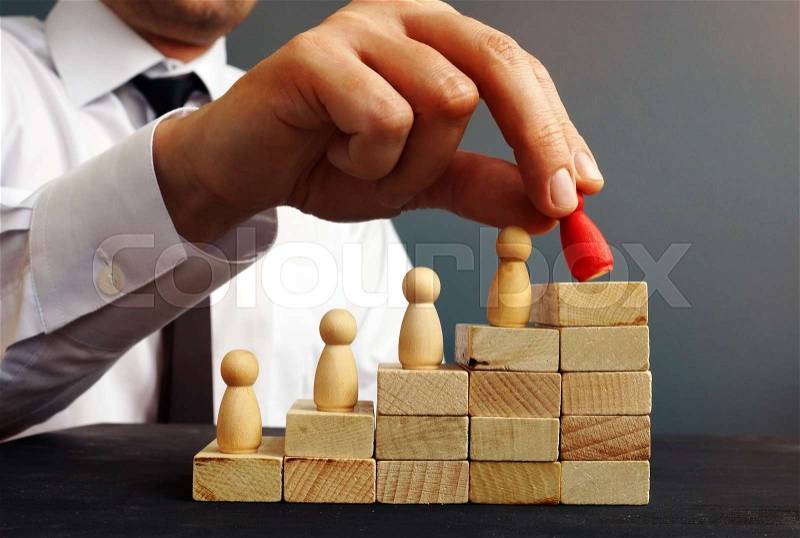 Job Promotion. Manager is holding figurine near career ladder. Worker raises, stock photo