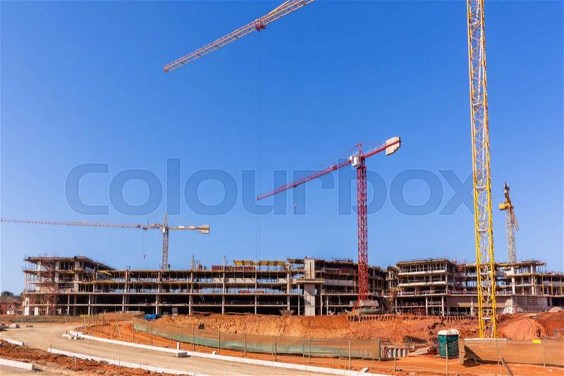 Building construction site cranes concrete levels earthworks halfway apartment housing project, stock photo