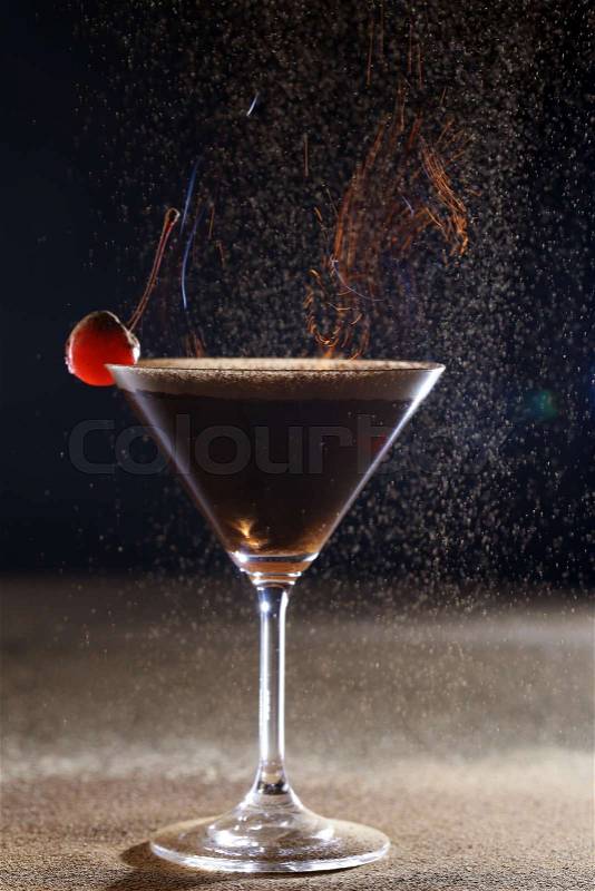 Martini glass with a cherry on a dark background, stock photo