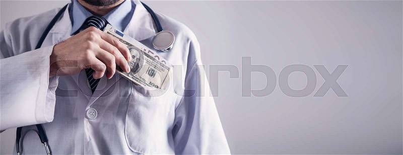 Doctor holding money. Concept of corruption, stock photo