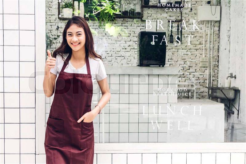 Portrait of woman small business owner smiling and standing outside the cafe or coffee shop.woman barista standing at cafe, stock photo