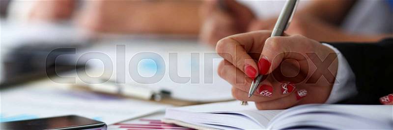 Female clerk arm make marks in notepad with silver pen closeup at office workplace. Audit paperwork financial inspector assistant fill survey form for job offer ..., stock photo