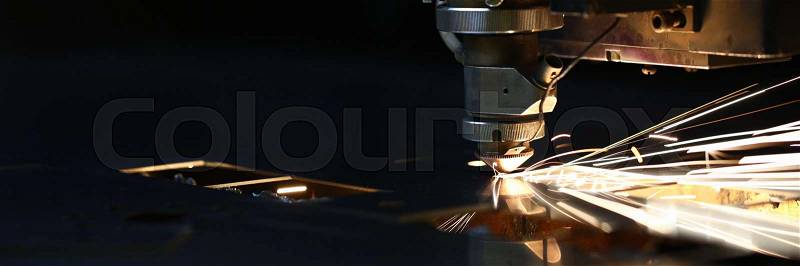 Sparks fly out machine head for metal processing laser metal on metallurgical plant background. Manufacturing finished parts for automotive production concept, stock photo