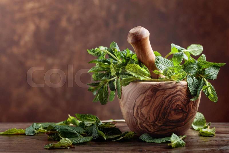 Bunch of fresh green organic mint in old mortar, stock photo