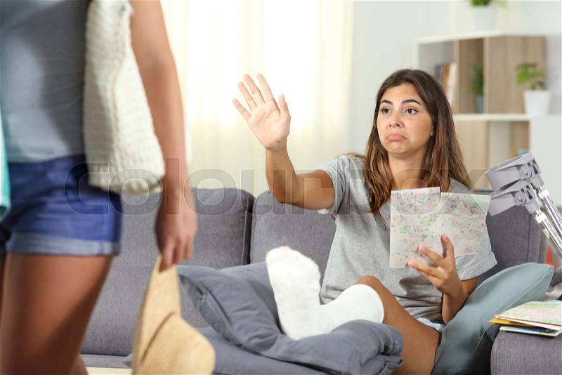 Disabled girl complaining staying at home on vacation and a friend leaving her, stock photo