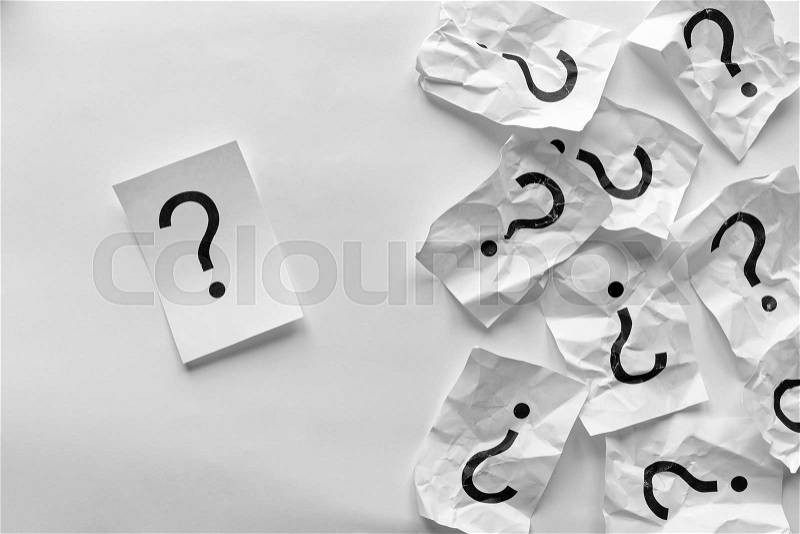 Individuality or leadership concept using question marks with one single one on clean paper and a pile on old crumpled pages over a white background with copy space, stock photo