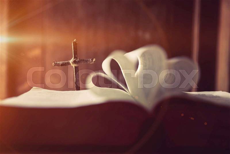 Cross with Bible on a old oak wooden table. Beautiful dark background. Religion concept , stock photo