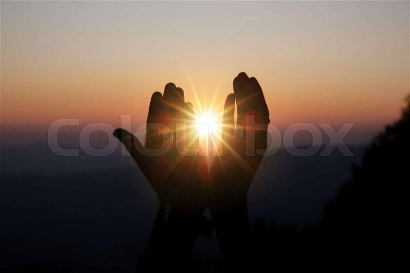 Faith of christian concept: Spiritual prayer hands over sun shine with blurred beautiful sunset background, stock photo