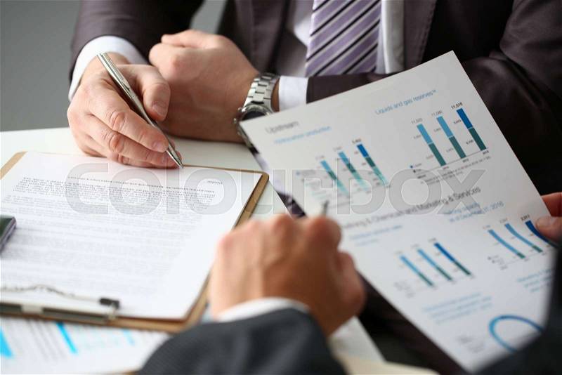 Male arm in suit and tie fill form clipped pad with silver pen closeup. Sign gesture read pact sale agent bank job make note loan credit mortgage investment finance ..., stock photo