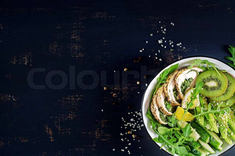 Buddha bowl dish with chicken fillet, avocado, cucumber, fresh arugula salad and sesame. Detox and healthy keto diet bowl concept. Overhead, top view, flat lay, copy ..., stock photo