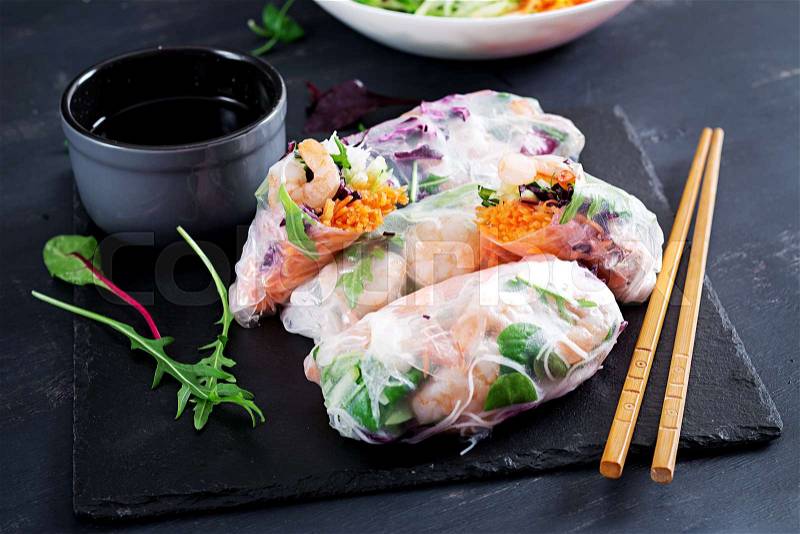 Vegetarian vietnamese spring rolls with spicy shrimps, prawns, carrot, cucumber, red cabbage and rice noodle. Seafood. Tasty meal. Copy space, stock photo