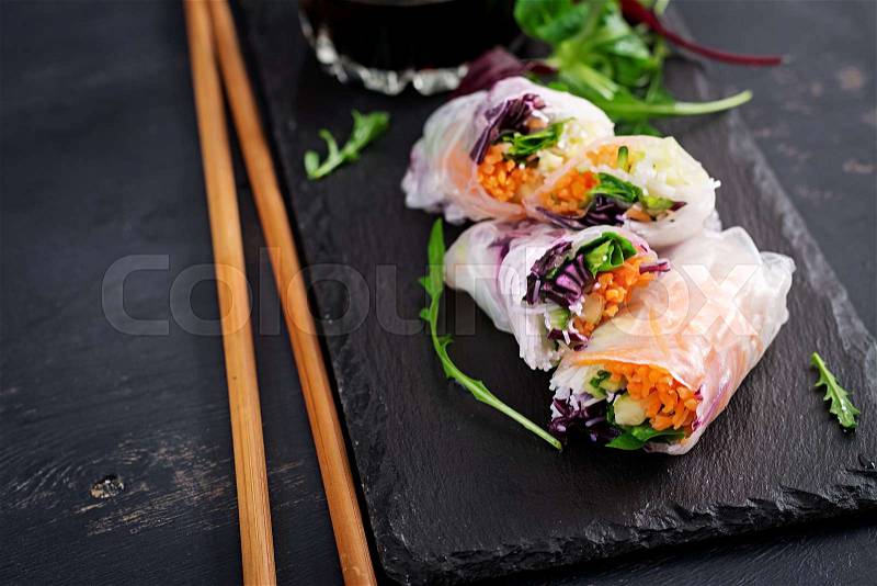 Vegetarian vietnamese spring rolls with spicy sauce, carrot, cucumber, red cabbage and rice noodle. Vegan food. Tasty meal. Copy space, stock photo