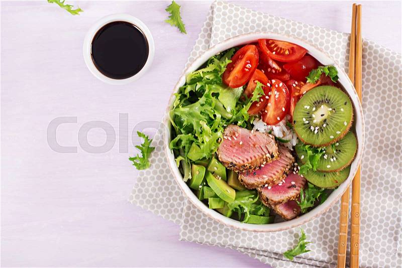 Poke bowl. Buddha bowl. Traditional salad with pieces of medium-rare grilled Ahi tuna and sesame with fresh vegetable salad and rice on a plate. Top view. Flat lay. ..., stock photo