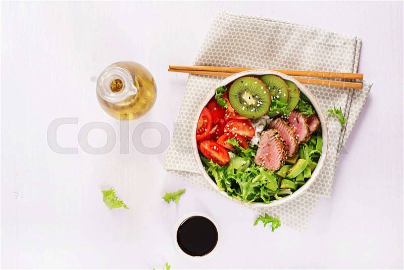Poke bowl. Buddha bowl. Traditional salad with pieces of medium-rare grilled Ahi tuna and sesame with fresh vegetable salad and rice on a plate. Top view. Flat lay. ..., stock photo