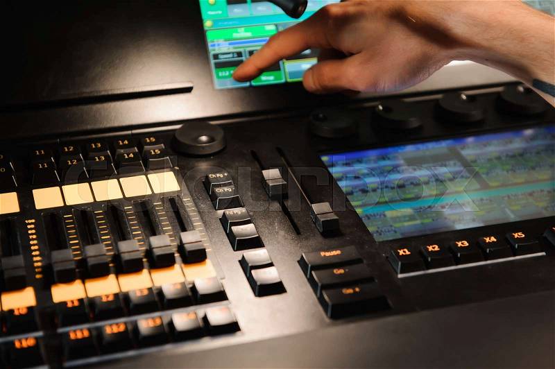 A lighting engineer works with lights technicians control on the concert show. Professional light mixer, mixing console. Equipment for concerts, stock photo