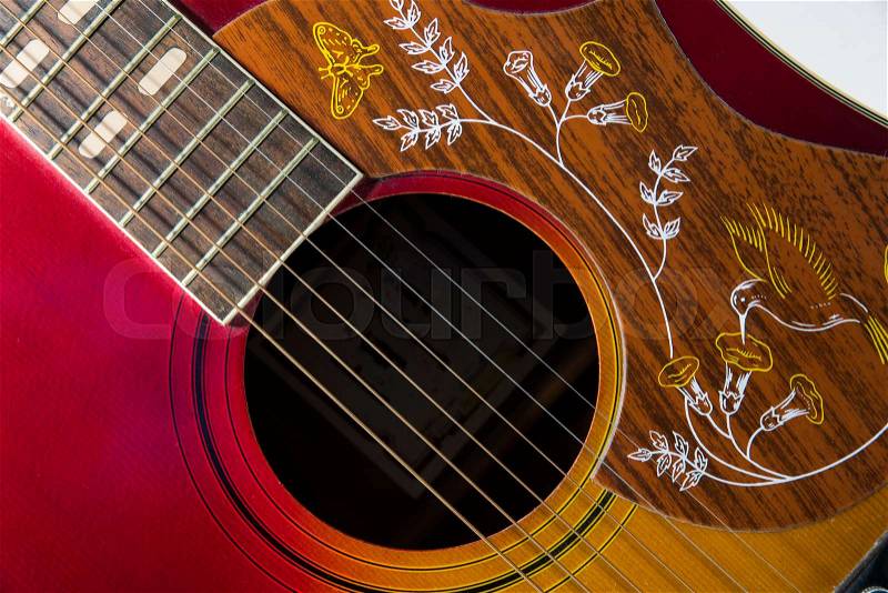 Red western guitar music instrument with the strings in close up, stock photo