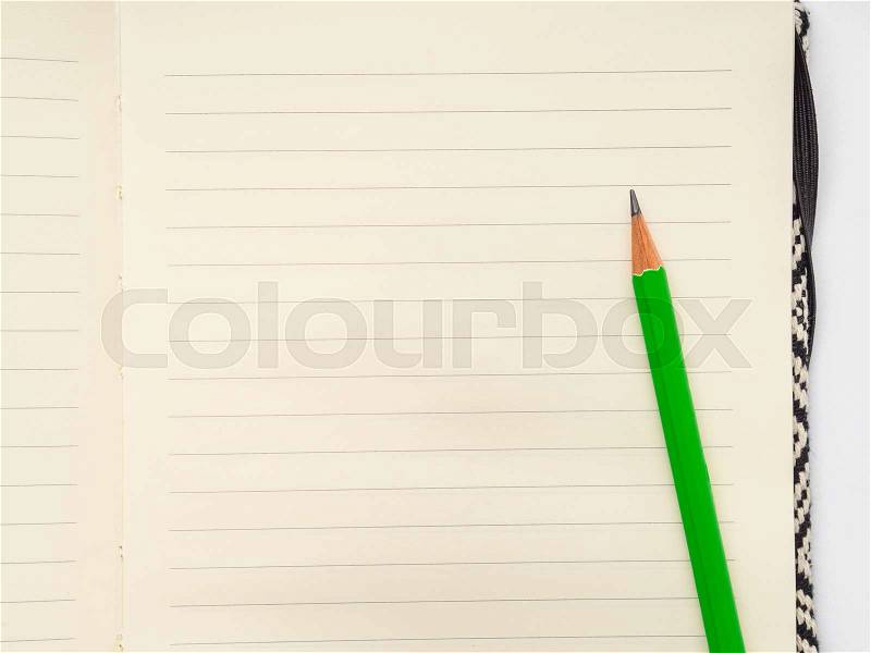 Blank page of lined notebook with green pencil, stock photo