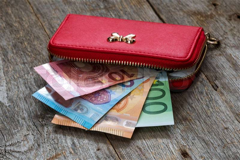 Red female wallet full of euro cash money banknotes, stock photo