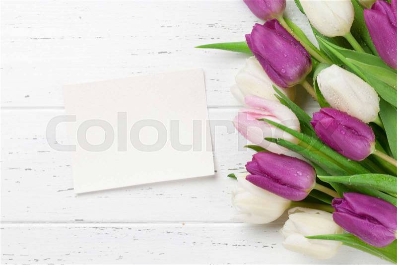 Easter greeting card with tulip flowers bouquet. Top view over white wooden table with space for your greetings, stock photo