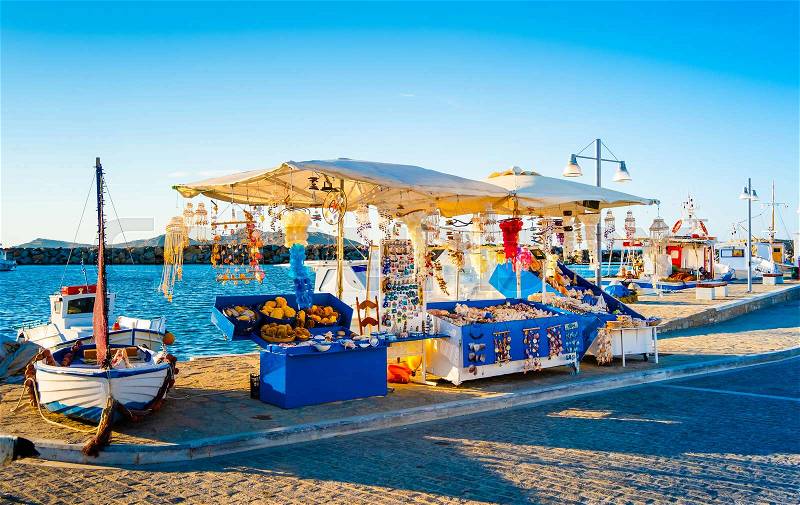 Summer evening view of souvenir booth at stony berth and turquoise bay of greek island Paros, stock photo