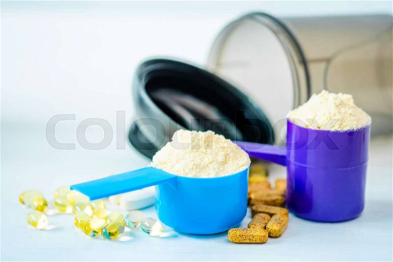 Sport Pills, vitamins and protein powder with brown bottle composed on a table, stock photo