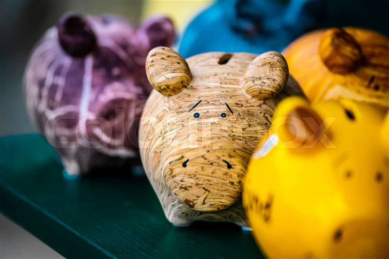 Colorful ceramic pig shape copycats on the wooden shelf, stock photo