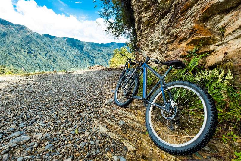 Black mountain bikes by the huge brown rock, stock photo