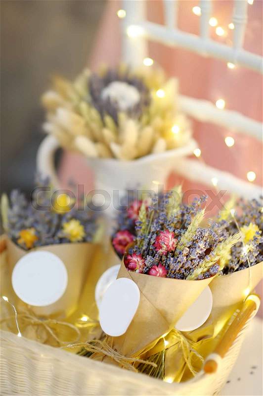 Beautiful dried flowers in paper boxes with lights on background. Wedding decorations close up. Floral design, stock photo