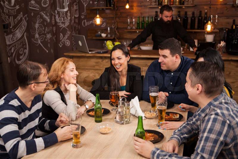 Old friends having fun in an old styled pub. Meeting in a hipster pub, stock photo