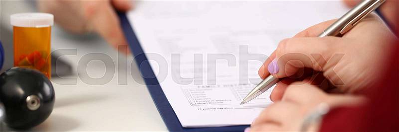 Female doctor hand hold silver pen filling patient history list at clipboard pad. Physical exam er disease prevention ward round visit check 911 prescribe remedy ..., stock photo